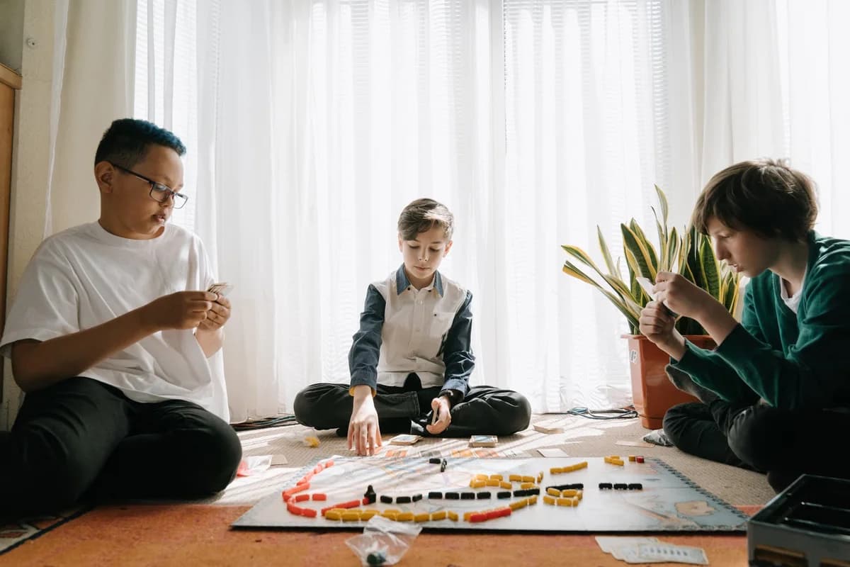 Three children playing a board game on the floor indoors.
